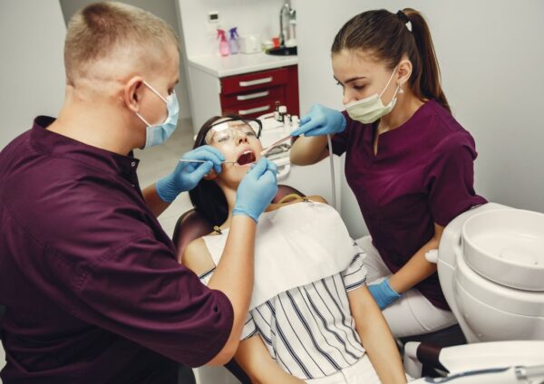 Dentist and assistant examining a patient for full mouth restoration in Kolkata at a modern dental clinic.