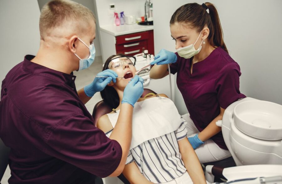 Dentist and assistant examining a patient for full mouth restoration in Kolkata at a modern dental clinic.